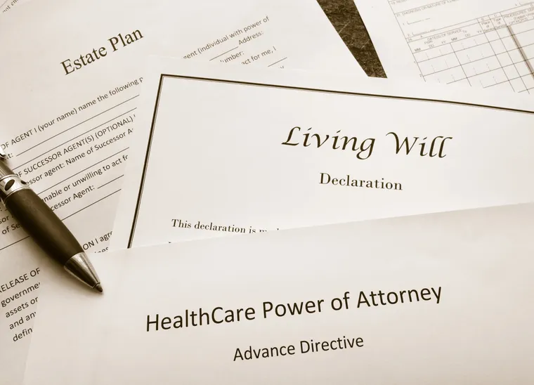 Estate planning paperwork — an estate plan, a living will declaration and a healthcare power of attorney — with a pen resting on top